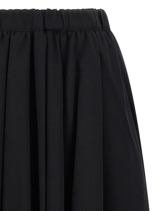 Black wool mini skirt by Comme Des Garçons, featuring a fitted design and stylish length, shown on a model.