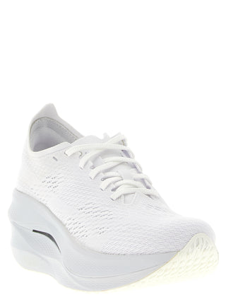 White synthetic athletic sneakers by Comme Des Garçons with sleek design and sporty look.