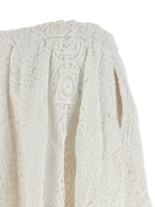 White cotton midi skirt by Comme Des Garçons, featuring a flowing design and midi length, displayed on a neutral background.