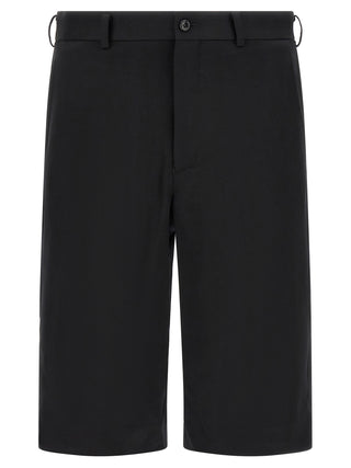 Black wool Bermuda shorts by Comme Des Garçons, featuring a tailored fit and classic design, shown on a plain background.
