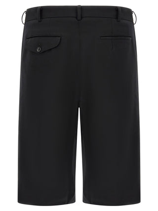 Black wool Bermuda shorts by Comme Des Garçons, featuring a tailored fit and knee-length design, displayed on a plain background.