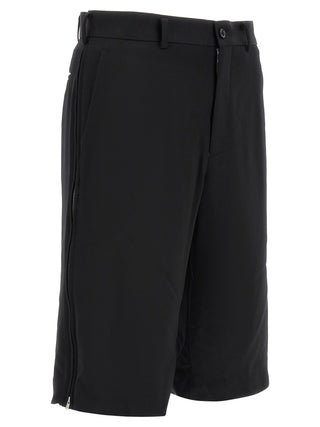 Black wool Bermuda shorts by Comme Des Garçons, featuring a tailored fit and knee-length design, displayed on a plain background.