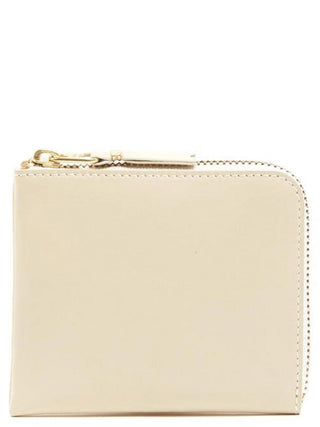 Beige cowhide cardholder by Comme Des Garçons with multiple card slots and sleek leather finish.