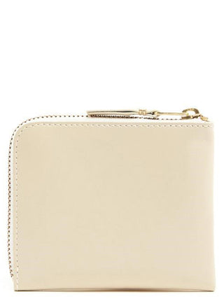 Beige cowhide cardholder from Comme Des Garçons with multiple card slots and sleek design.