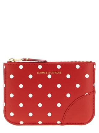 Red calfskin cardholder from Comme Des Garçons featuring multiple card slots and sleek, minimalist design.