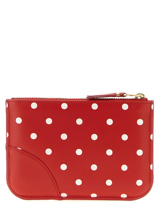 Red calfskin cardholder from Comme Des Garçons with multiple card slots and sleek minimalist design.