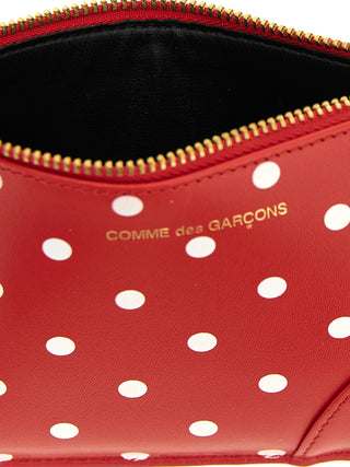 Red calfskin cardholder by Comme Des Garçons with multiple card slots and sleek minimalist design.