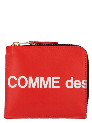 Red cowhide cardholder by Comme Des Garçons featuring multiple card slots and a sleek minimalist design.