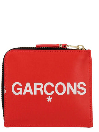Red cowhide cardholder by Comme Des Garçons with multiple card slots and sleek minimalist design.