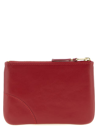 Red calfskin cardholder by Comme Des Garçons with multiple card slots and sleek, minimalist design.