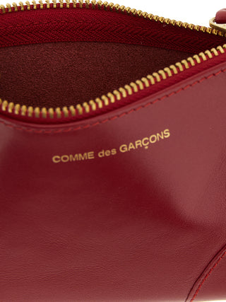 Red calfskin cardholder from Comme Des Garçons featuring multiple card slots and a sleek, minimalist design.