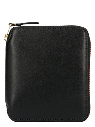 Black calfskin wallet by Comme Des Garçons with multiple card slots and sleek design, shown open with visible interior compartments.