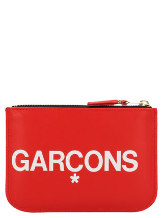 Red calfskin cardholder by Comme Des Garçons with multiple card slots and sleek minimalist design.