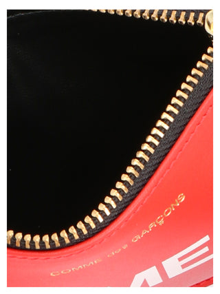 Red calfskin cardholder by Comme Des Garçons with multiple card slots and sleek minimalist design.