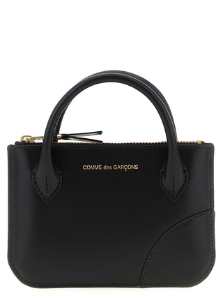 Black cowhide cardholder by Comme Des Garçons with multiple card slots and sleek minimalist design.
