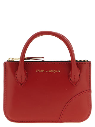 Red cowhide cardholder by Comme Des Garçons with multiple card slots and sleek minimalist design.