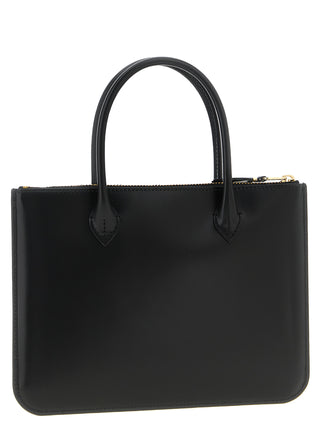 Black cowhide handbag by Comme Des Garçons featuring a sleek design with sturdy handles and minimalist style.