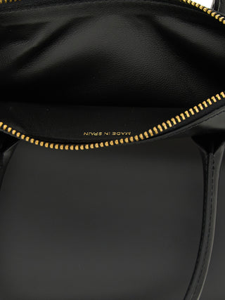 Black cowhide handbag by Comme Des Garçons with sleek design and top handle, showcasing textured leather and minimalist style.