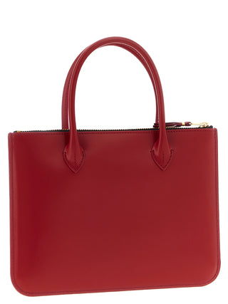 Red cowhide handbag by Comme Des Garçons featuring a sleek design and durable leather construction.