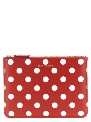 Red calfskin wallet by Comme Des Garçons featuring a sleek, minimalist design with multiple card slots and a smooth finish.