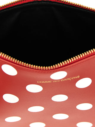 Red calfskin wallet by Comme Des Garçons with sleek, minimalist design and multiple card slots.
