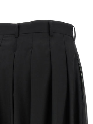 Black wool pants by Comme Des Garçons, tailored fit with classic design, displayed on a hanger.