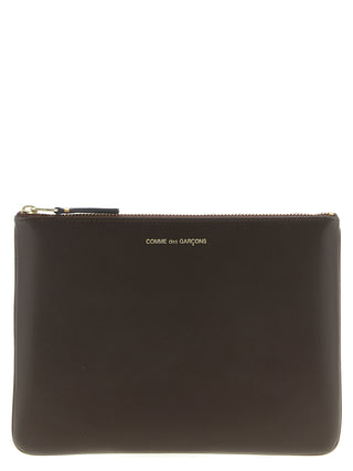Brown cowhide cardholder by Comme Des Garçons with multiple card slots and a sleek, minimalist design.