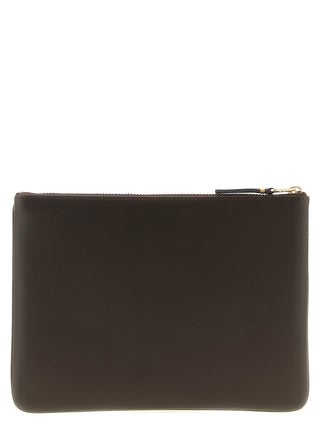 Brown cowhide cardholder by Comme Des Garçons with multiple card slots and sleek design.
