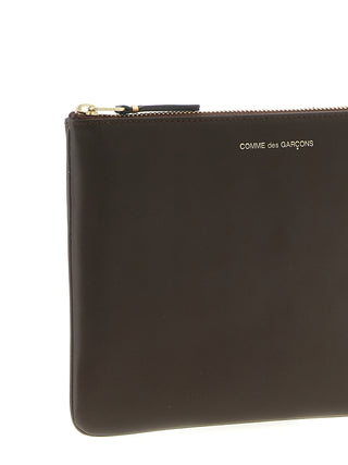 Brown cowhide cardholder by Comme Des Garçons with multiple card slots and a sleek, minimalist design.