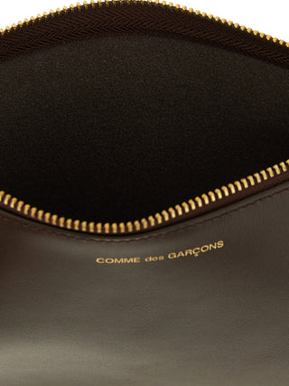 Brown cowhide cardholder by Comme Des Garçons with multiple card slots and sleek minimalist design.