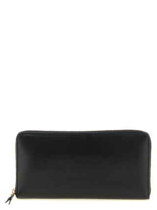 Black calfskin wallet by Comme Des Garçons with sleek design and multiple card slots, shown open with visible interior details.