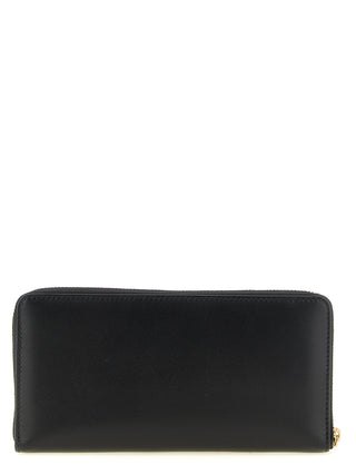 Black calfskin wallet by Comme Des Garçons with sleek design and multiple card slots.