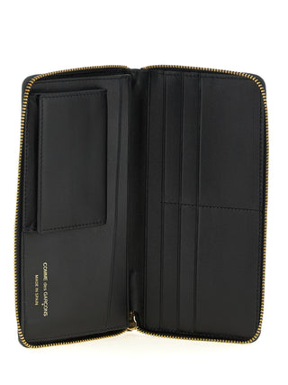 Black calfskin wallet by Comme Des Garçons featuring sleek design and multiple card slots.