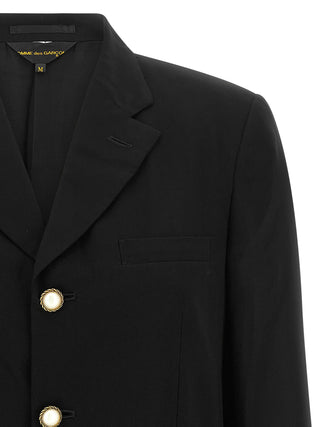 Black polyester blazer by Comme Des Garçons, tailored fit with notch lapels and button closure, shown on a mannequin.