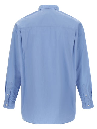 Blue cotton blouse by Comme Des Garçons, featuring a relaxed fit and stylish design, shown on a hanger.