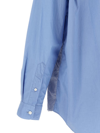 Blue cotton blouse by Comme Des Garçons, featuring a relaxed fit and classic collar, shown on a hanger.