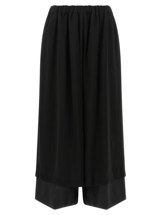 Black wool casual pants by Comme Des Garçons, featuring a relaxed fit and minimalist design, shown in a front view.