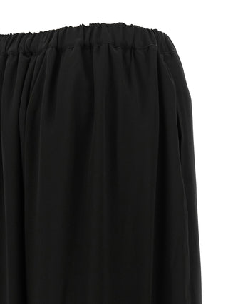 Black wool casual pants by Comme Des Garçons, showing relaxed fit and tailored design with side pockets.