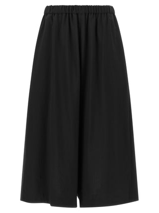 Black wool cropped pants by Comme Des Garçons, featuring a tailored fit and modern style, shown on a model.