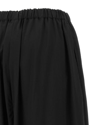Black wool cropped pants by Comme Des Garçons, tailored fit with a modern cropped length and sleek design.