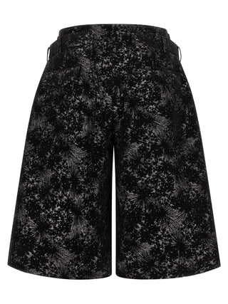 Black polyester Bermuda shorts by Comme Des Garçons, featuring a relaxed fit and casual style, shown on a model.