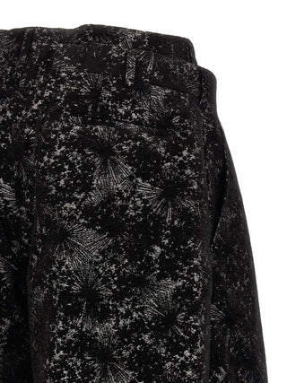 Black polyester Bermuda shorts by Comme Des Garçons, showing a mid-length casual fit with a smooth, lightweight fabric.