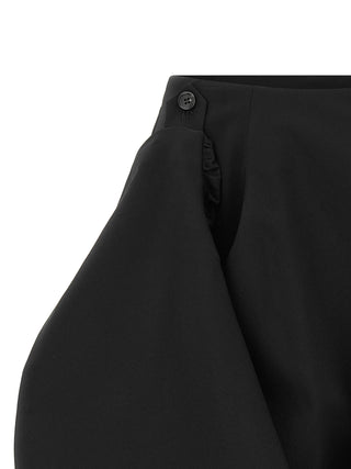 Black wool midi skirt by Comme Des Garçons, featuring a high waist and sleek silhouette, displayed on a neutral background.