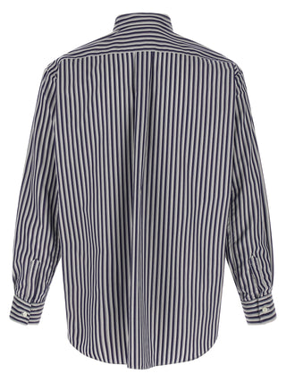 Blue cotton blouse by Comme Des Garçons displayed on a hanger, showcasing its relaxed fit and minimalist design.