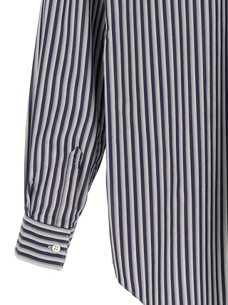 Blue cotton blouse by Comme Des Garçons, featuring a relaxed fit and minimalist design, shown on a hanger.