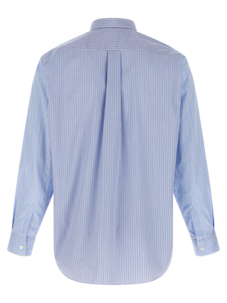 Blue cotton blouse by Comme Des Garçons, featuring a relaxed fit and minimalist design, shown on a hanger.