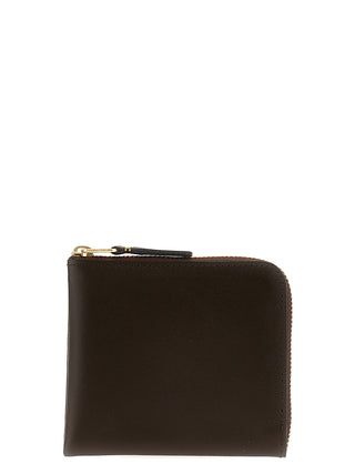 Brown cowhide cardholder from Comme Des Garçons with multiple card slots and sleek design.