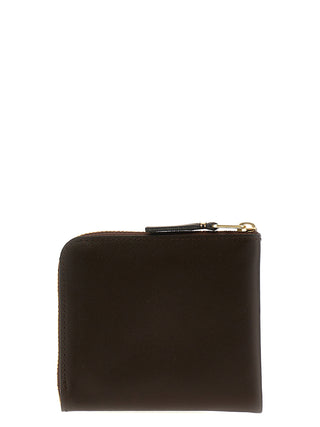 Brown cowhide cardholder by Comme Des Garçons with multiple card slots and a sleek, minimalist design.