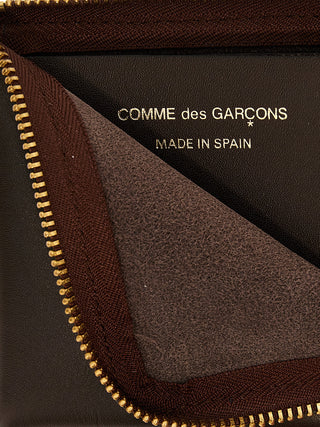 Brown cowhide cardholder by Comme Des Garçons featuring multiple card slots and sleek minimalist design.