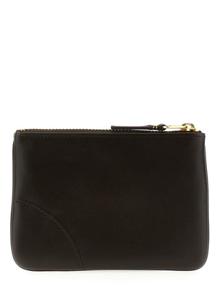 Brown calfskin cardholder by Comme Des Garçons with multiple card slots and smooth leather finish.